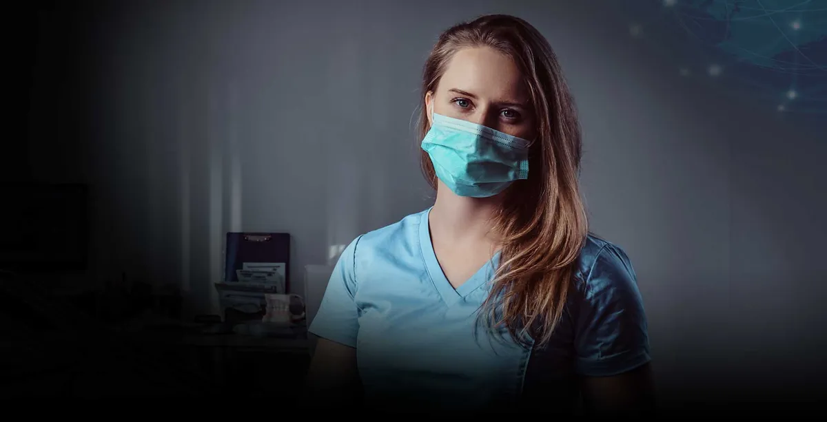 Una mujer en uniforme azul sentada en una silla dental