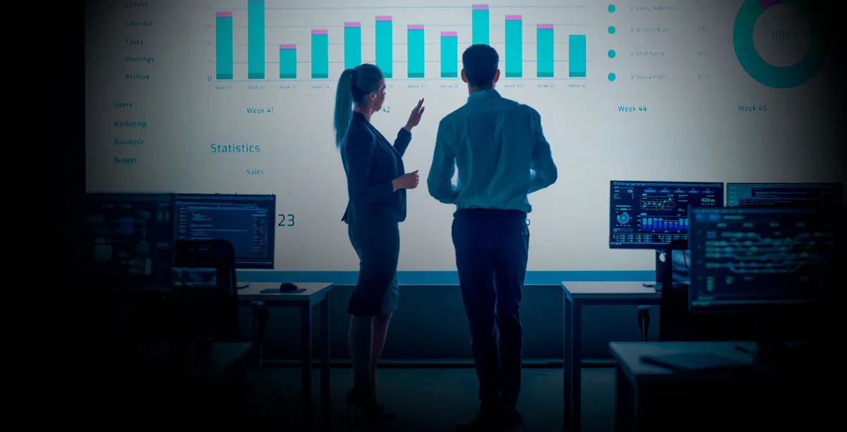 Dos profesionales analizan intensivamente datos de Big Data aplicada a los negocios en un pizarrón y diseñan estrategias para optimizar el rendimiento organizacional.