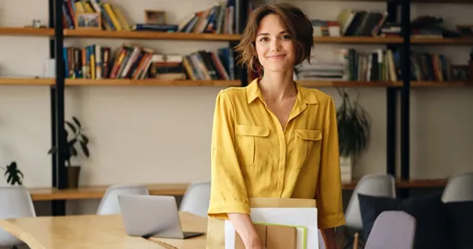 Una mujer que hace cursos universitarios sostiene una carpeta