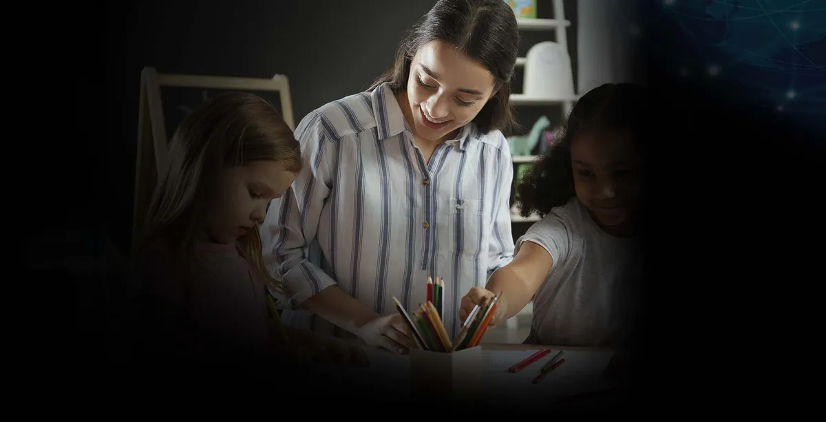 Una maestra ayudando a niñas con sus tareas escolares.