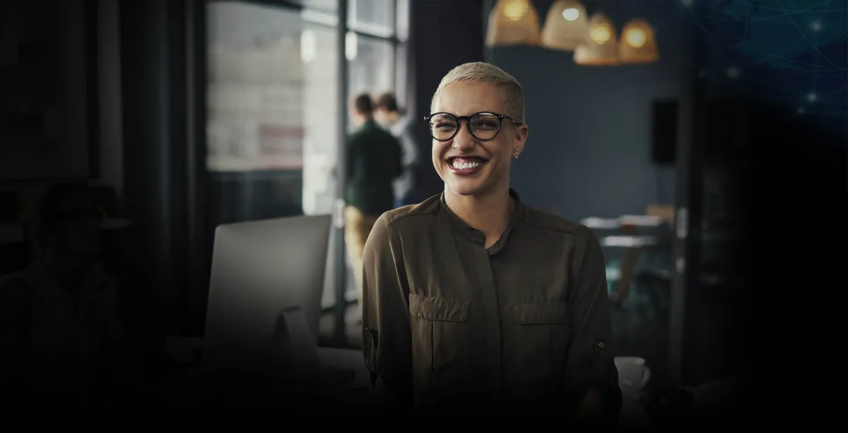 Mujer sonriendo en oficina, donde se desempeña como profesional de estrategia comercial.