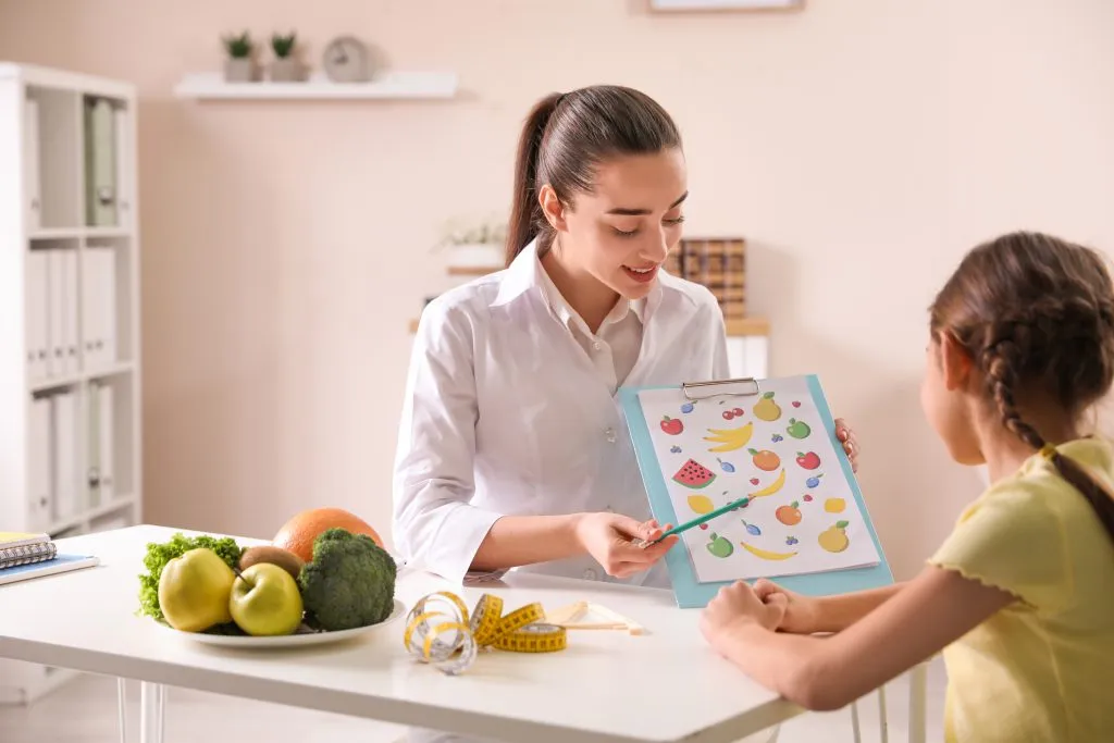 Nutricionista infantil en consulta con un paciente y sus padres