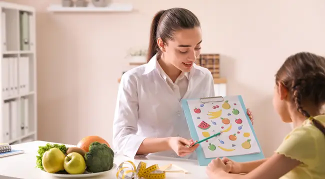 Nutricionista infantil en consulta con un paciente y sus padres 
