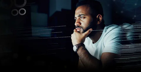 Un hombre observando una pantalla de computadora con datos en ella.