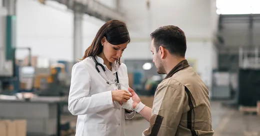 Una mujer especialista en seguridad y salud ocupacional atiende a un trabajador